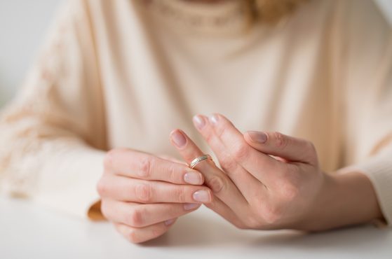 Woman taking off wedding ring