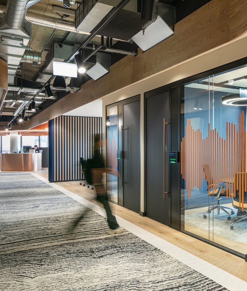Manchester office, a figure walks into a meeting room