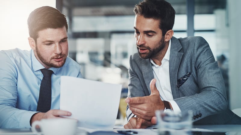 A business man and a lawyer review a report