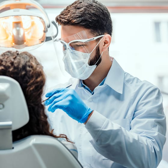 A dentist treating a patient in their dental practice