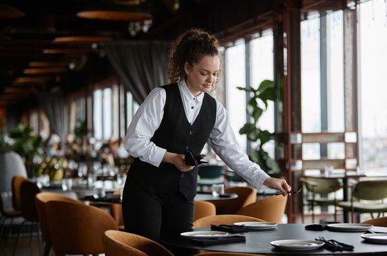 A server sets a table in a restaurant