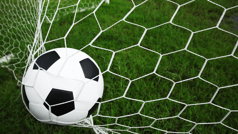 A football is caught in the back of a football goal net
