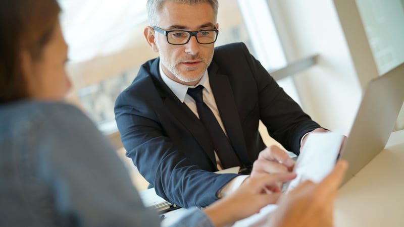 A man in a suit reviews a policy