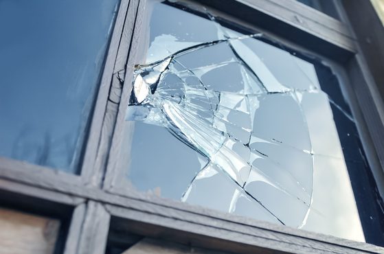 A smashed window which has been damaged by antisocial behaviour