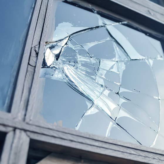 A smashed window which has been damaged by antisocial behaviour