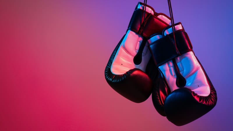 Boxing gloves hanging down with red and blue background