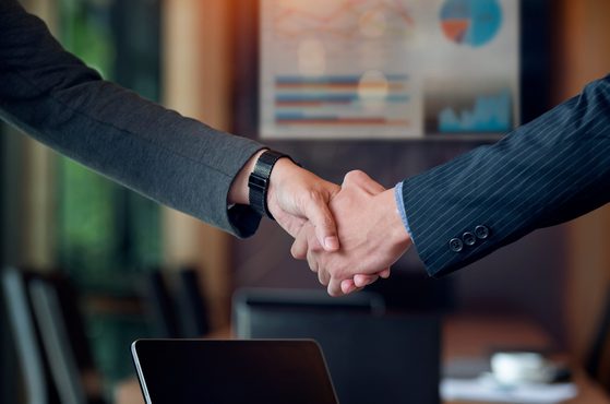 Business owners shake hands following an acquisition