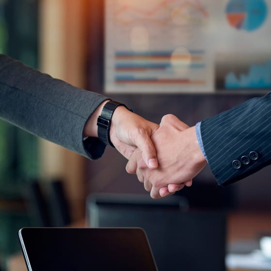 Business owners shake hands following an acquisition