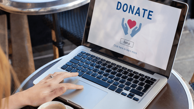 A charitable donation is made online on a laptop