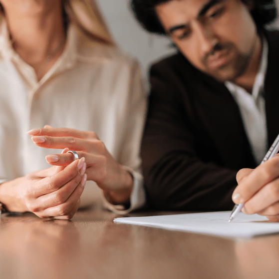 Divorcing couple sign papers and remove their rings