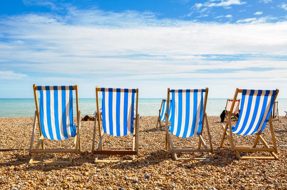 Four deckchairs on a UK beach during a heatwave