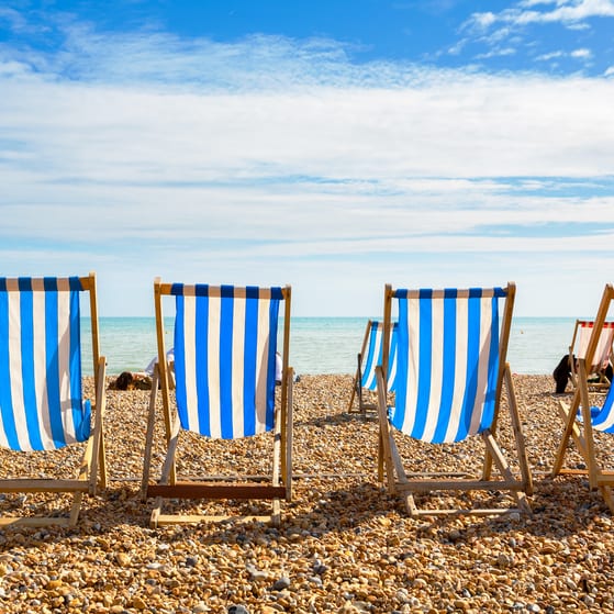 Four deckchairs on a UK beach during a heatwave