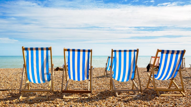 Four deckchairs on a UK beach during a heatwave