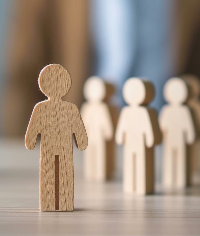 Leader Choosing Team Member Among Wooden Figures on Table