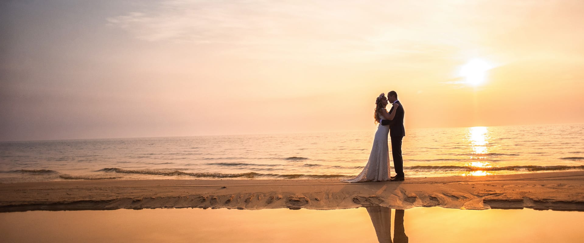 Newly married couple embracing on beach 2