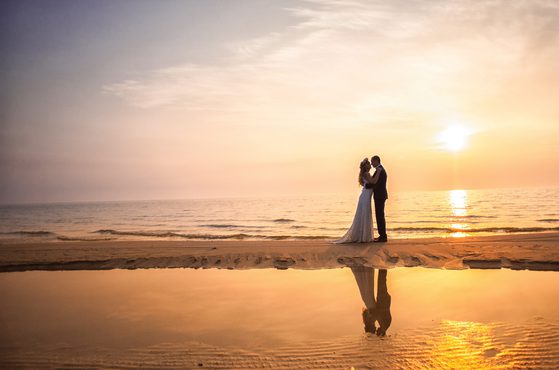 Newly married couple embracing on beach 2