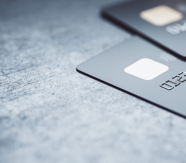 Online payments concept with black credit cards on abstract blank dark surface