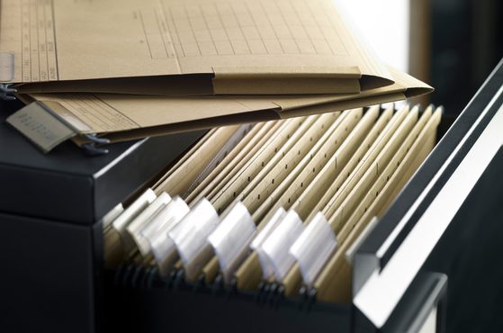 Open filing cabinet with various documents