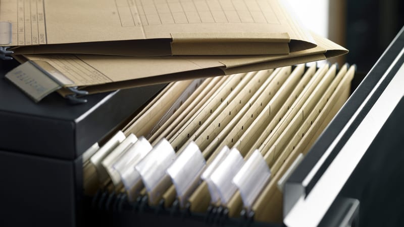 Open filing cabinet with various documents