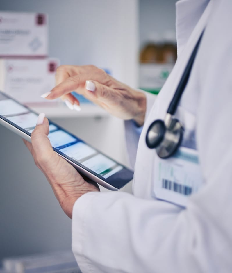 Pharmacist using tablet explores available medicines