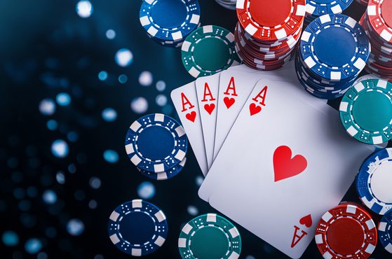 Poker chips and four ace of hearts cards