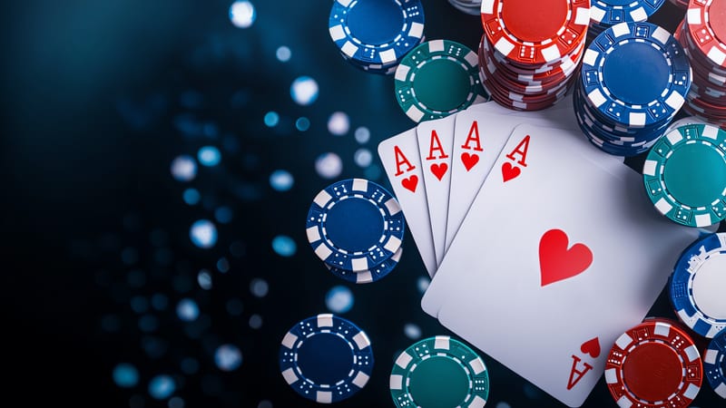 Poker chips and four ace of hearts cards