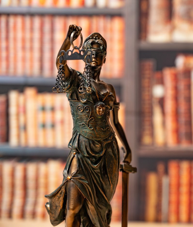 Scales of justice in front of bookshelf