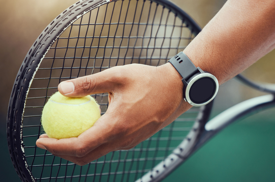 Tennis player holds a ball to a racket
