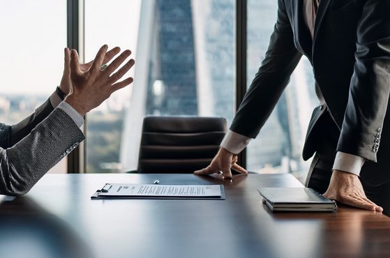 Two businesspeople disagreeing at a boardroom table