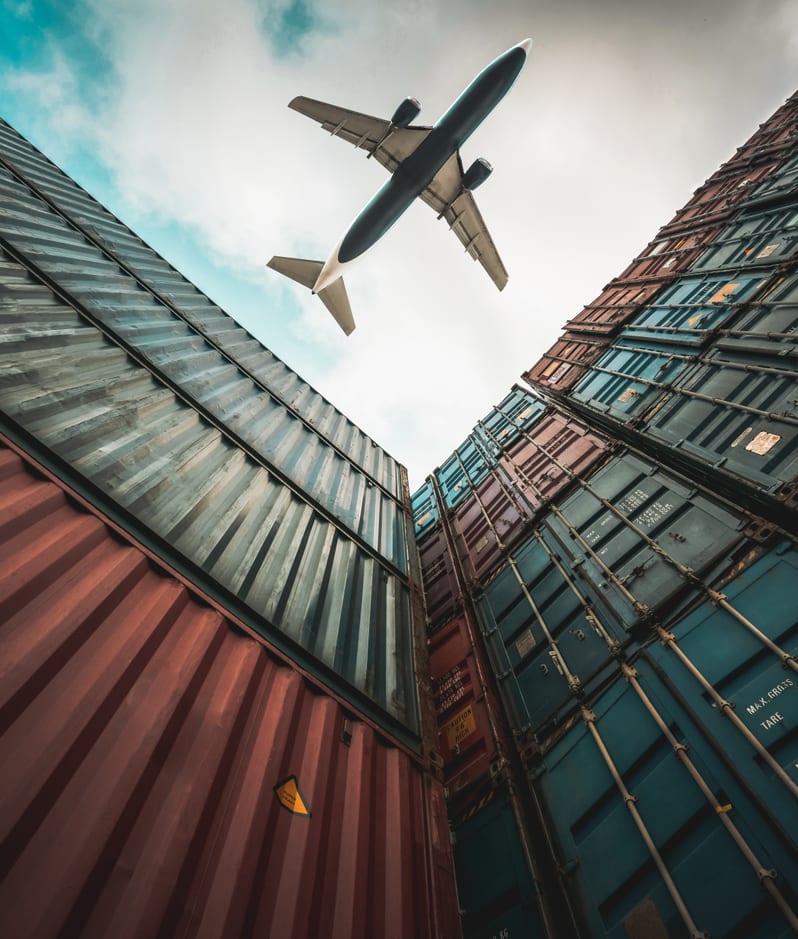 Warehousing logistics plane flying over shipping containers