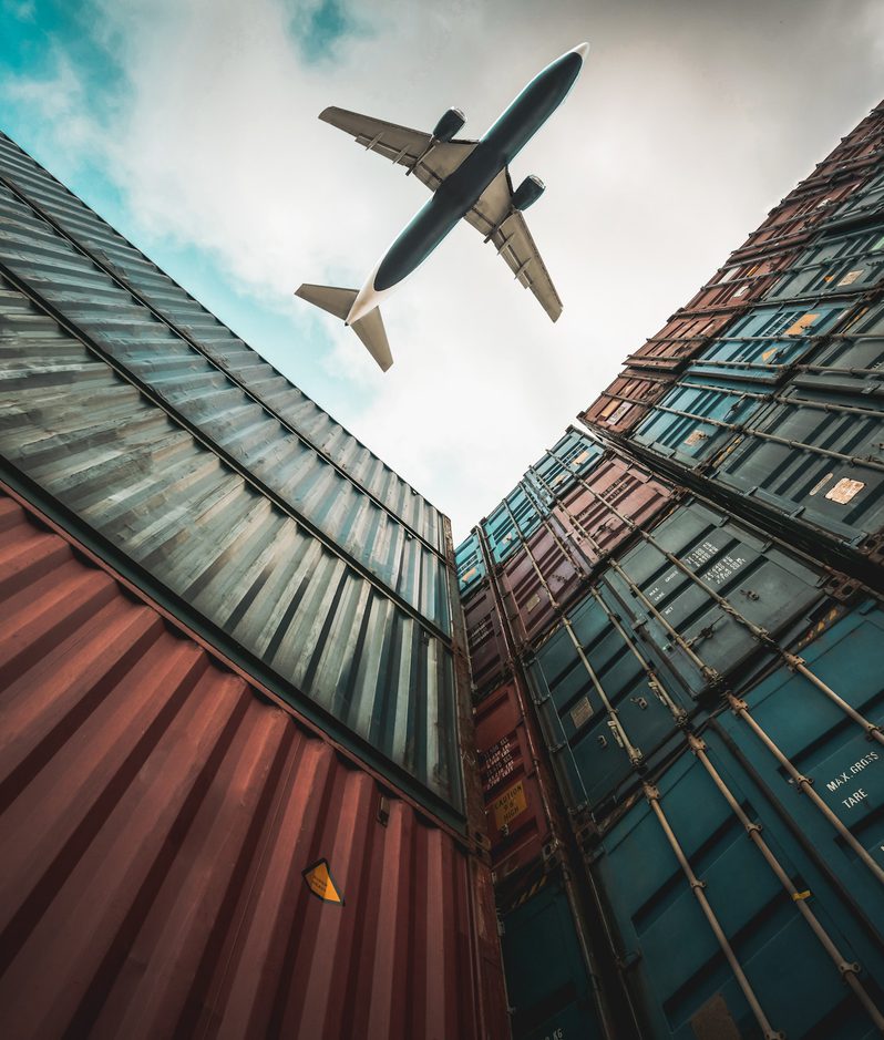 Warehousing logistics plane flying over shipping containers