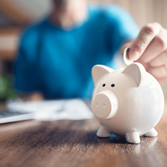A man puts money into a piggy bank pension concept