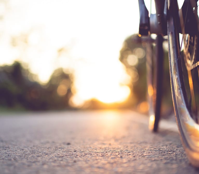 Bicycle wheels on road at sunset