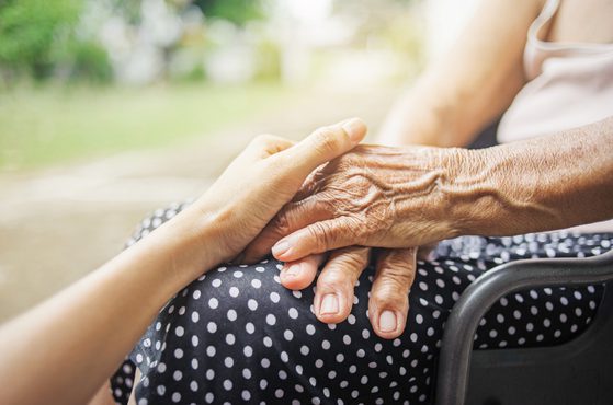 Hospice staff holding patients hand end of life