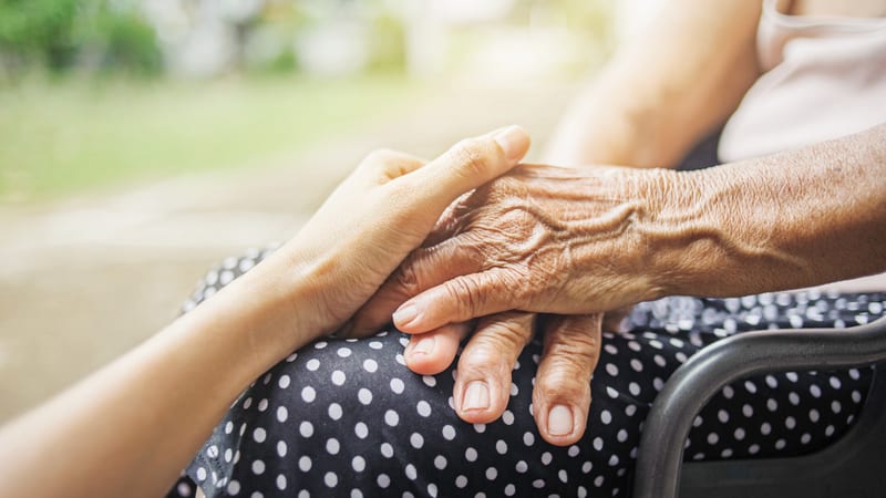 Hospice staff holding patients hand end of life