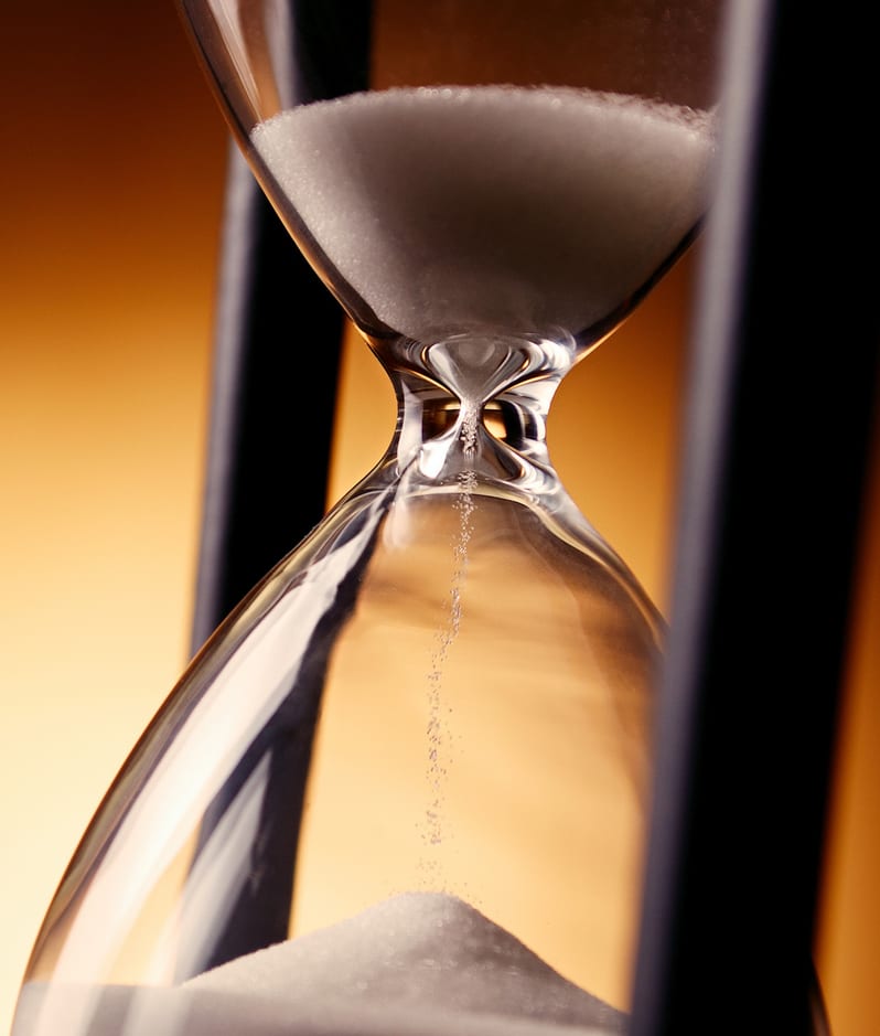 Hourglass with frame running out on orange background