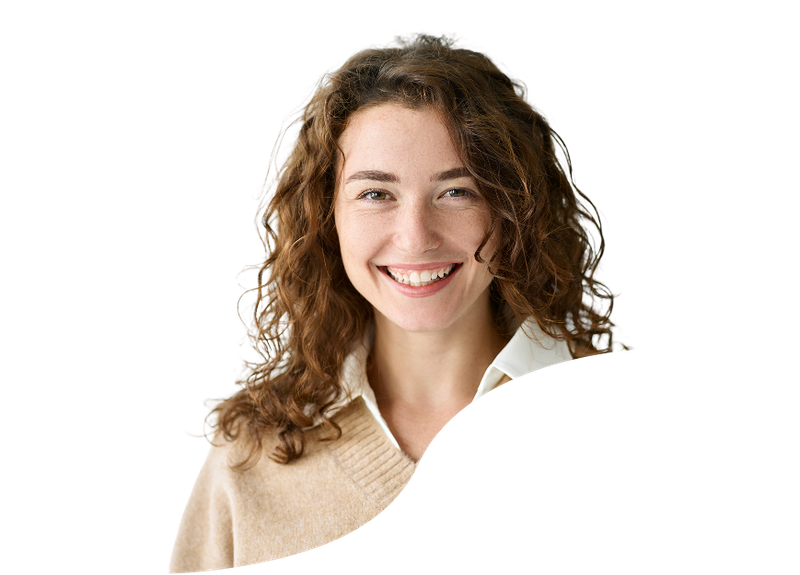 A smiling woman with curly brown hair, wearing a beige sweater over a white shirt, facing forward against a plain background.