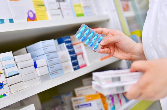 Pharmacy pharmacist getting pills off shelf