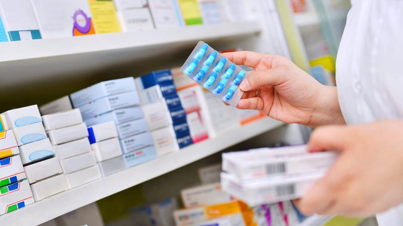Pharmacy pharmacist getting pills off shelf