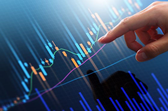 Pointing finger at trading graph on screen