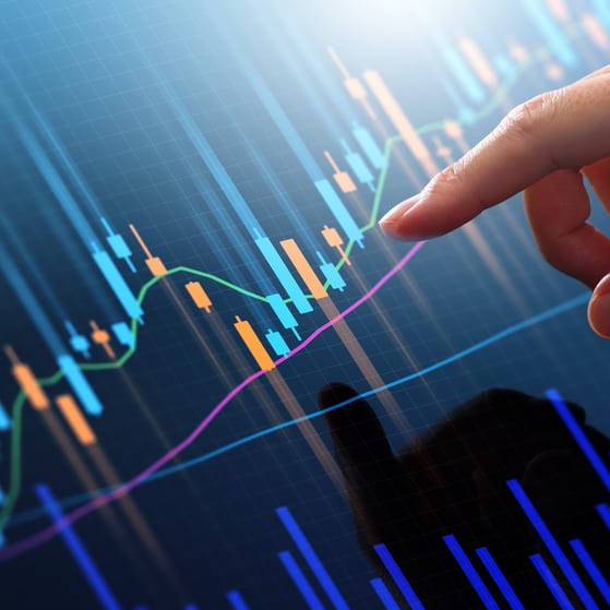 Pointing finger at trading graph on screen