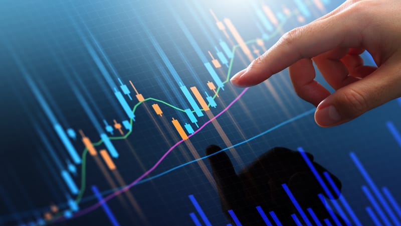 Pointing finger at trading graph on screen