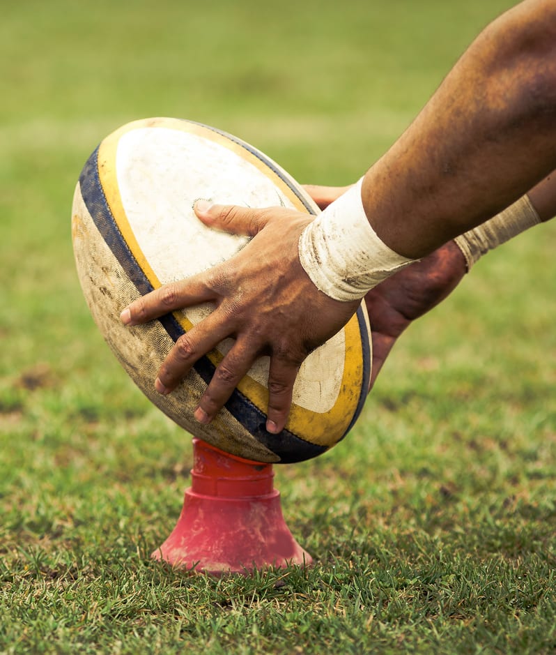 Rugby player placing ball down for kick