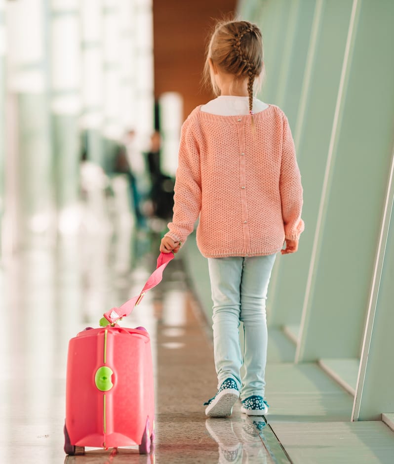 Little girl at airport in big international airport near window ready for vacation