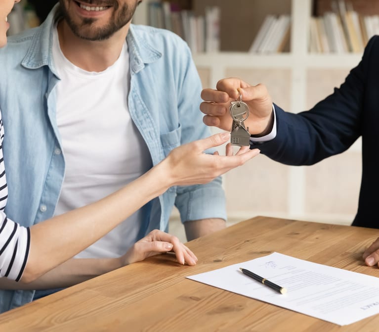 Rental property manager hands over property keys to a couple