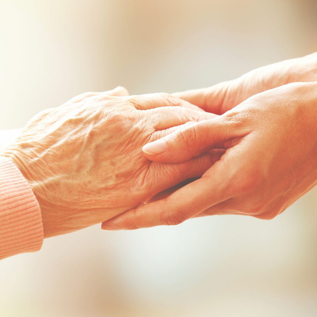 Holding the hand of an elderly person who has a lasting power of attorney