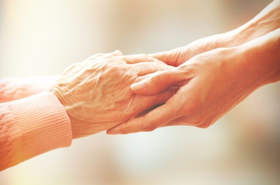 Holding the hand of an elderly person who has a lasting power of attorney