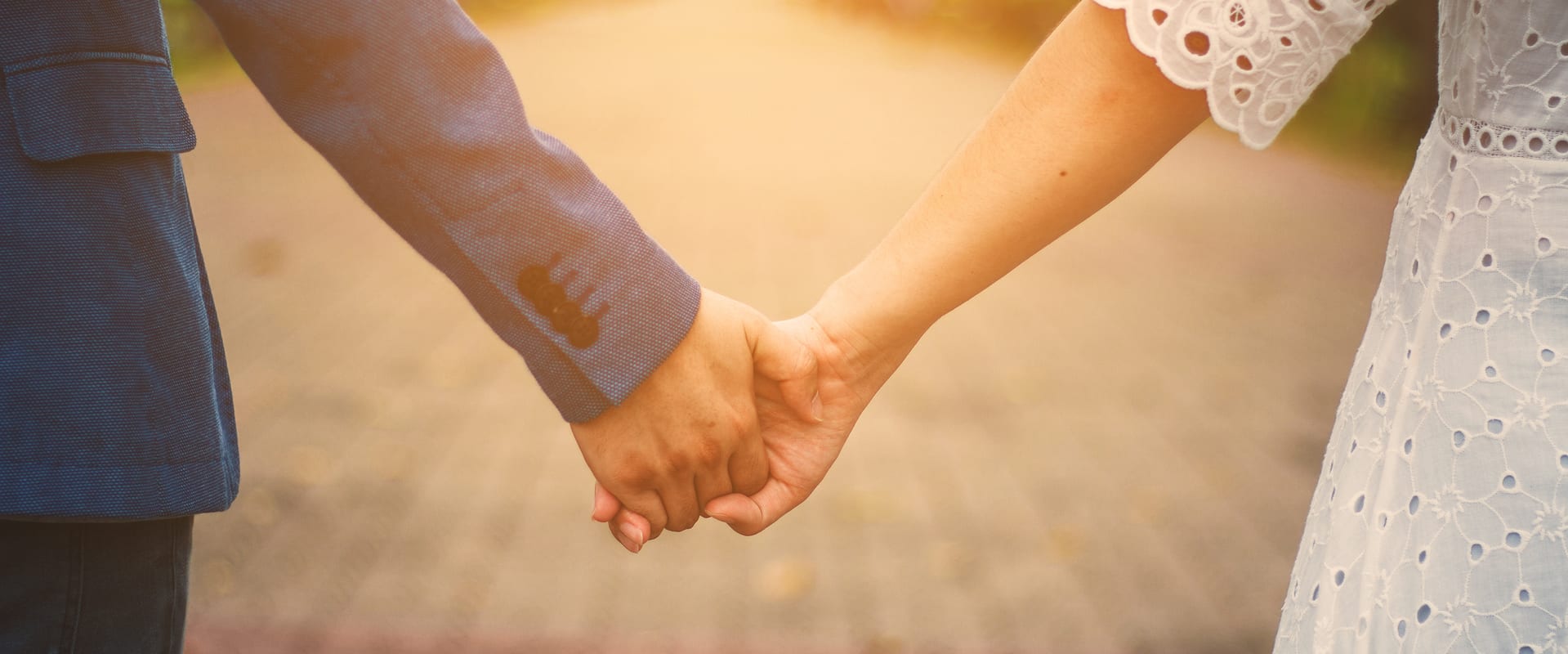 A couple hold hands on their wedding day