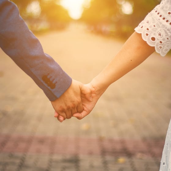 A couple hold hands on their wedding day