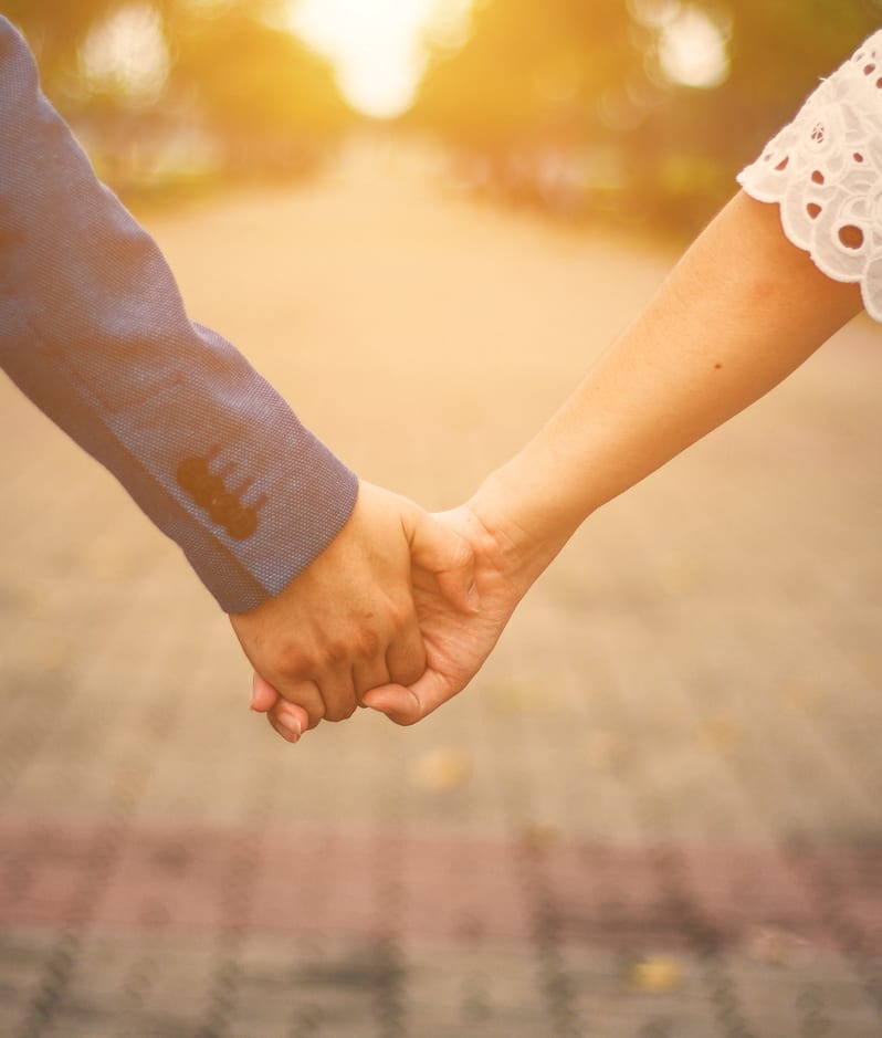 A couple hold hands on their wedding day